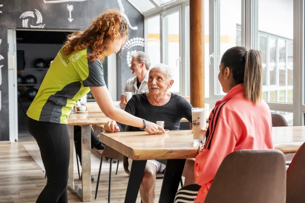 Gespräch am Tisch im Wohnzimmer des Sportparks