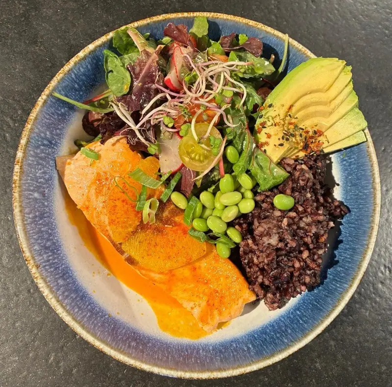 Lachs Bowl mit Salat, schwarzem Reis, Avocado und Edamame